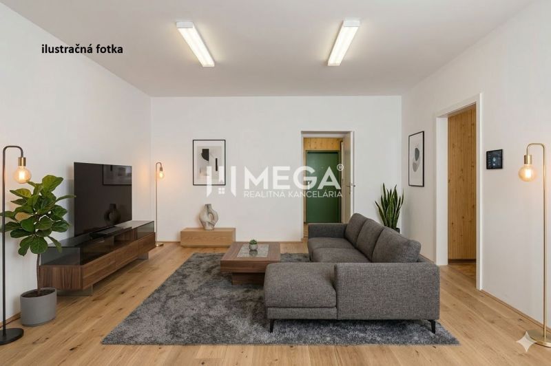 Commercial space with a wood-patterned floor, gray sofa, and plants.