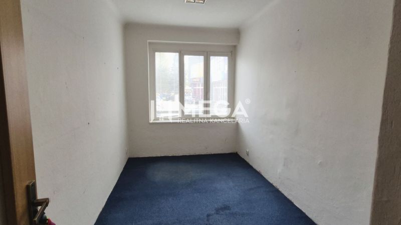 Room with a blue carpet and a window in commercial premises.