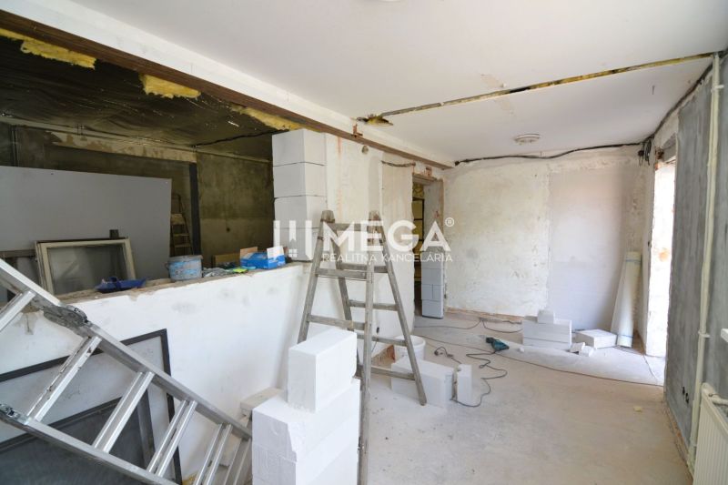 Production premises under construction with a ladder and building materials, floor with wooden decor.