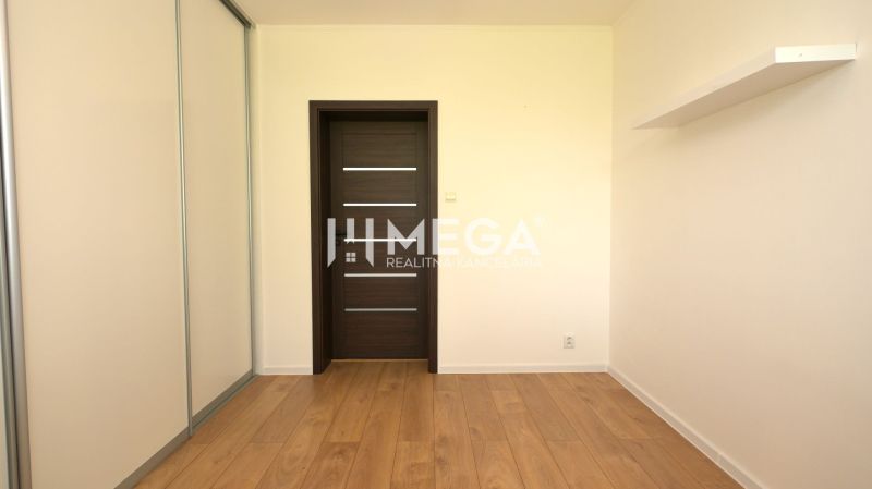 A room in a family house with a wooden decor floor and a wardrobe.