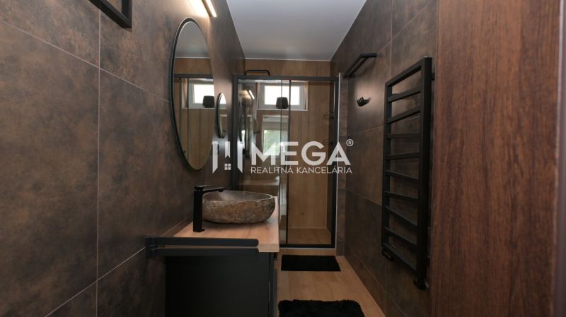Bathroom in a family house with a mirror, sink, and dark walls.