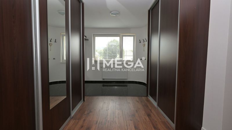 A hallway in a family house with a wooden decor floor and built-in wardrobes.