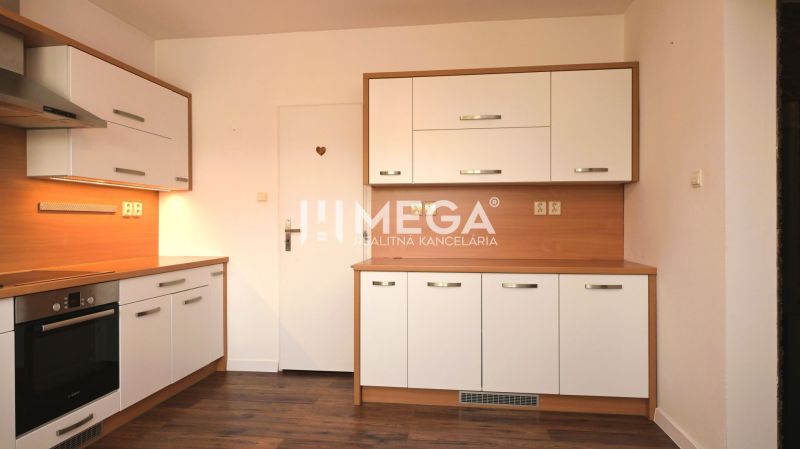 A kitchen in a family house with white cabinets, appliances, and a wooden decor floor.