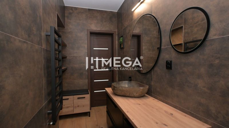 Bathroom interior in a family house with a mirror, sink, and wooden decor flooring.