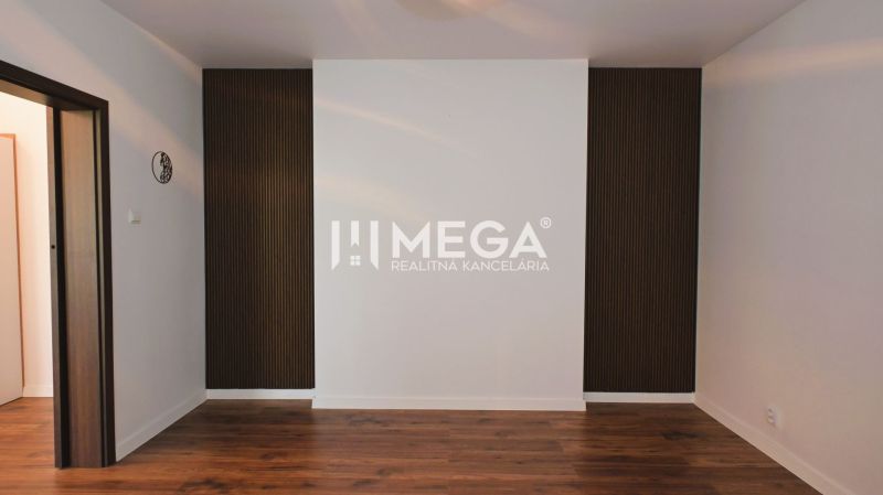 White wall and dark wooden paneling in a family house, floor with wood decor.