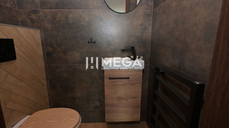 A bathroom in a family house with brown tiles and a wooden decor floor.