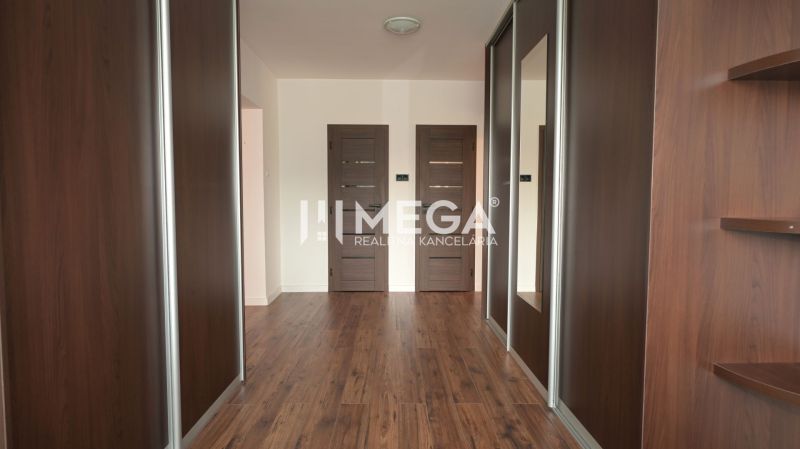 A hallway in a family house with a wood-patterned floor and built-in wardrobes.
