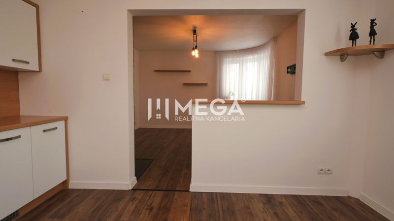 Interior of a family house with a wooden decor floor, kitchen unit, and shelves.
