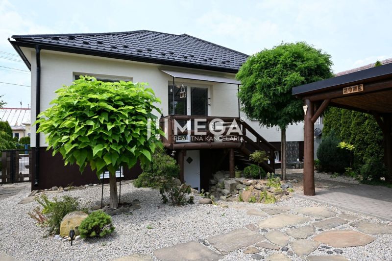 A family house in Udavské with a well-maintained garden and a stone driveway.