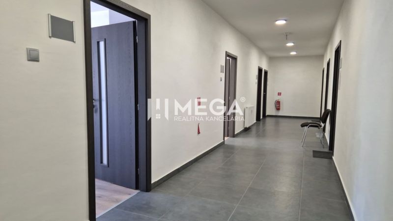 A corridor with multiple offices, tiled flooring, and open doors in the offices.