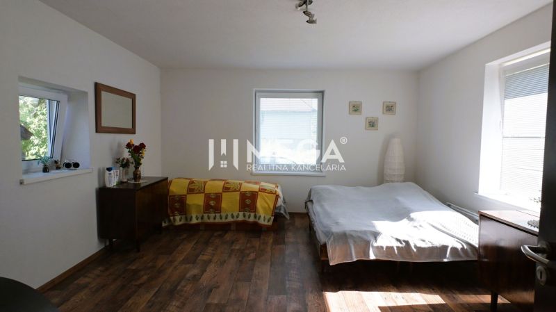 Bedroom in a family house with a bed, cabinet, and wooden decor flooring.