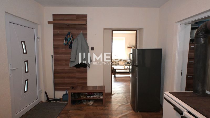 Interior of a family house with a wooden decor floor, hallway, and coat rack.