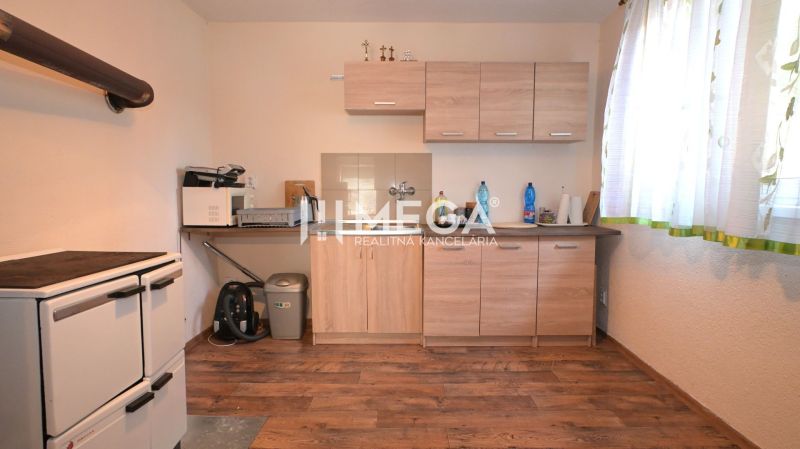 A kitchen in a family house with a wooden floor decor and light furniture.