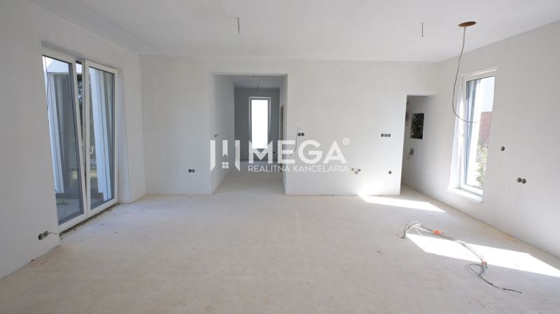 A spacious room in a family house with windows and unfinished work.