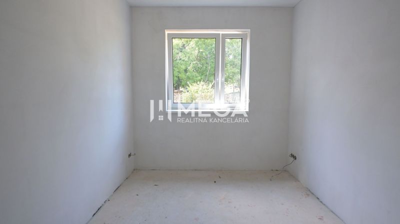 An empty room in a family house with white walls and a window.