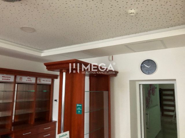 The interior of a building with glass display cases and a clock on the wall.