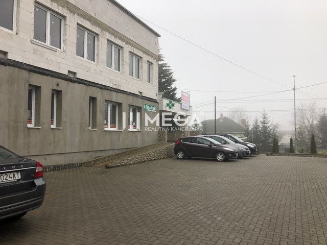 Building on SNP Street in Snina with a parking lot in front of the building and parked cars.