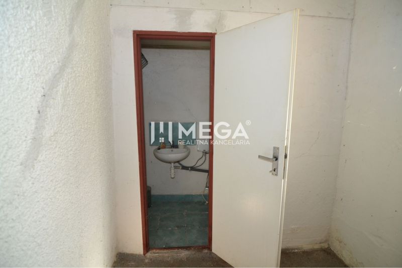 A small room with a sink and white walls in commercial premises.