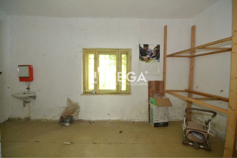 Commercial space with a simple sink, shelves, and a window, without flooring with a wooden decor.