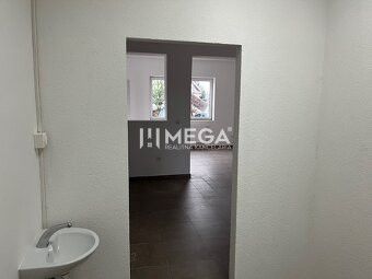 Interior of commercial premises with a sink and doors, floor with wooden decor.