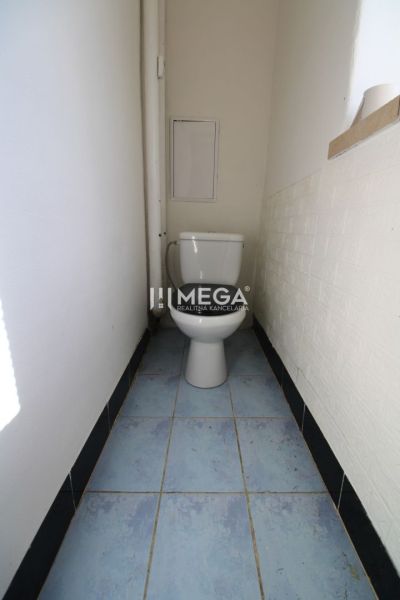 A bathroom in a 3-room apartment with a toilet and blue tiles.
