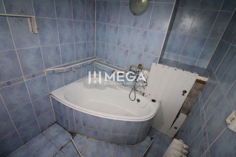 A bathroom with blue tiles and a bathtub in a 3-room apartment.