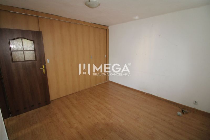A room in a 3-room apartment with a wooden decor floor and a built-in wardrobe.