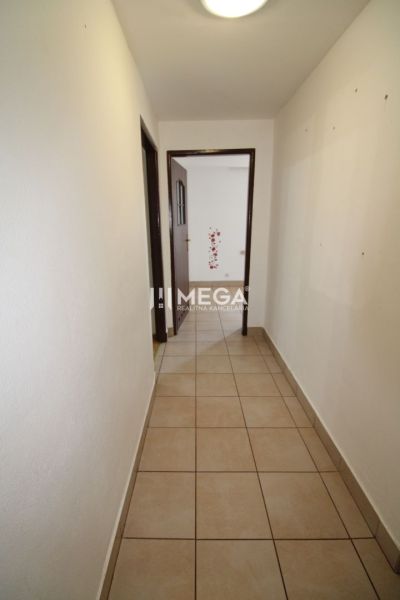 A hallway with light walls and tiles in a 3-room apartment.
