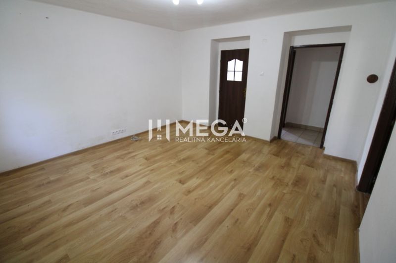 A room in a 3-room apartment with a wooden decor floor and white walls.