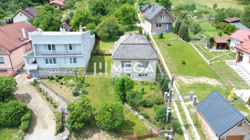 A family house on Jesenského Street in Snina surrounded by a garden and neighboring houses.