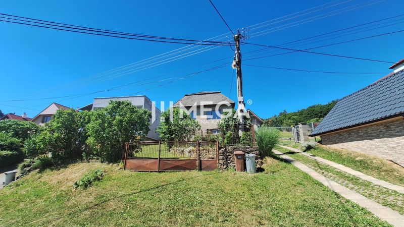 A family house on Jesenského Street in Snina surrounded by greenery and fencing.