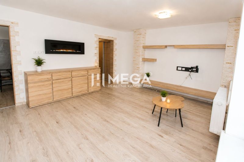 Living room in a 3-room apartment with wood-patterned flooring, light-colored walls, and furniture.
