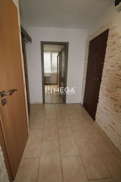 A hallway with light tiles in a 3-room apartment with entrance doors.
