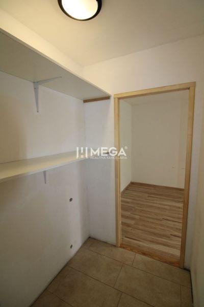 An entrance hall with shelves and a wooden decor floor in a 3-room apartment.