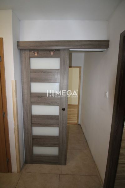 Sliding doors in a 3-room apartment with a wooden decor floor and tiles.