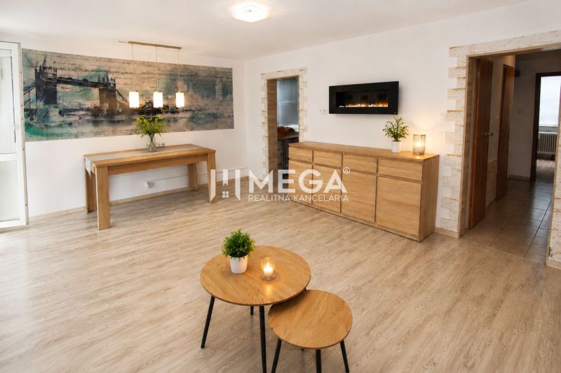 A stylish living room in a three-room apartment with a wooden decor floor.