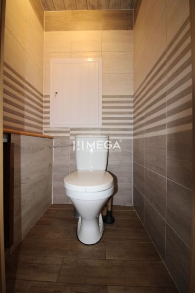 Bathroom in a 3-room apartment with tiles and a wooden decor floor.