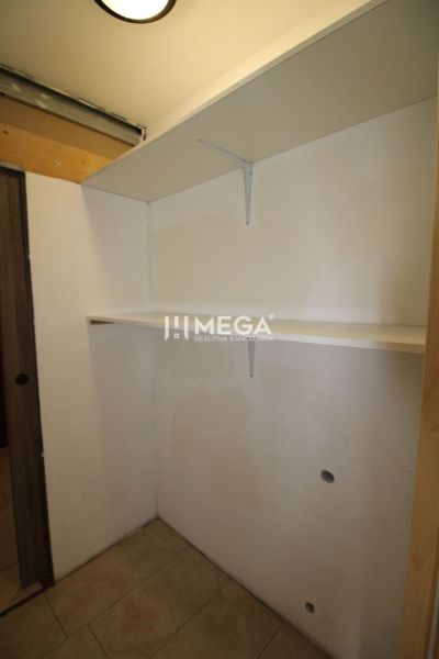 Storage space with shelves in a 3-room apartment, white walls and light flooring.