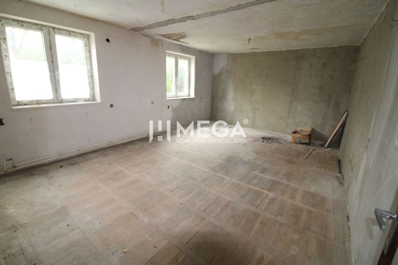 Construction in a 5 or more room apartment with wood-patterned flooring and raw walls.