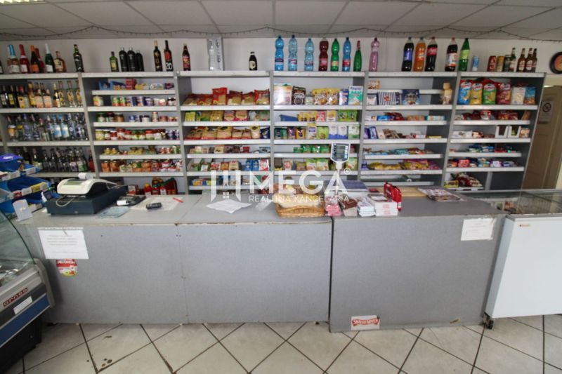 A grocery store with a counter and shelves in a family house, various products for sale.