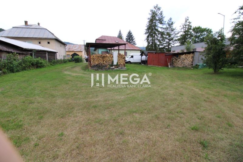 Garden at the family house in Ulič on Ulič 131 street with a grassy area and wood.