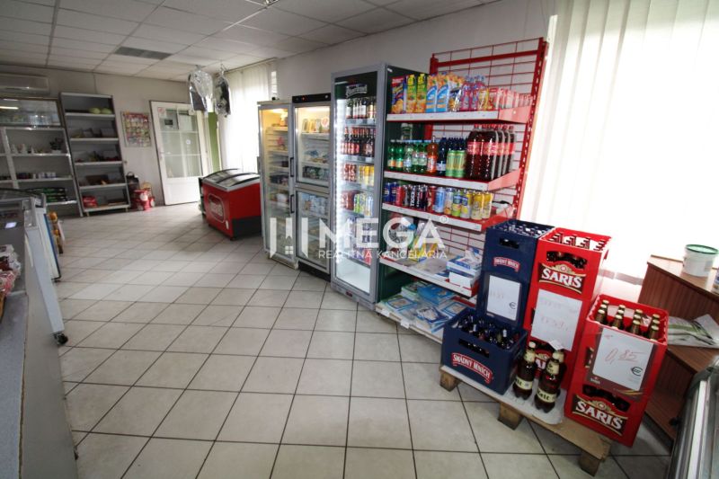 A shop with drinks and groceries in a family house with refrigerators and shelves.