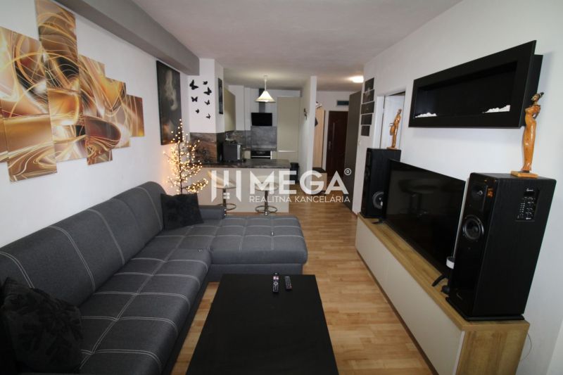Living room in a 2-room apartment with a corner sofa and a floor with a wooden decor.