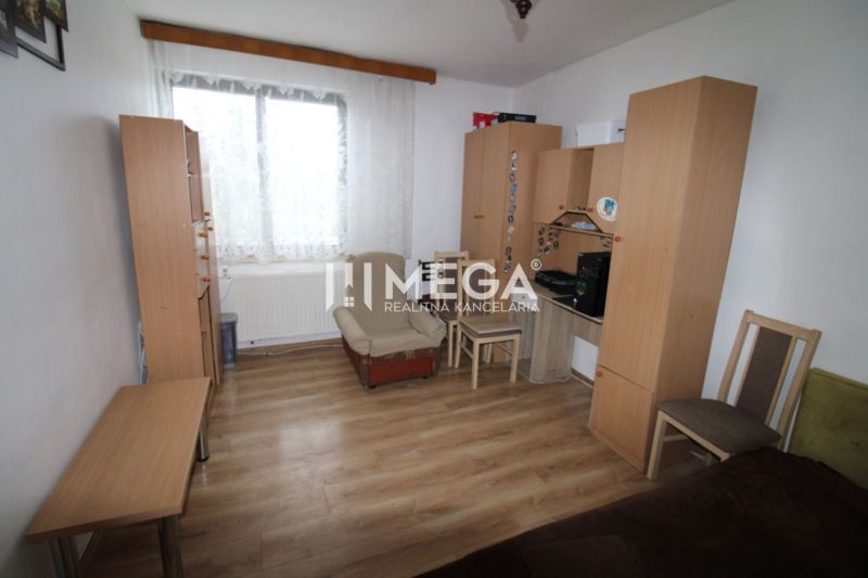 A room with wooden decor, furniture, an armchair, and a table in a family house.