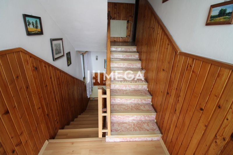 A staircase in a family house with wooden paneling, a floor with a wooden decor, decorations on the walls.