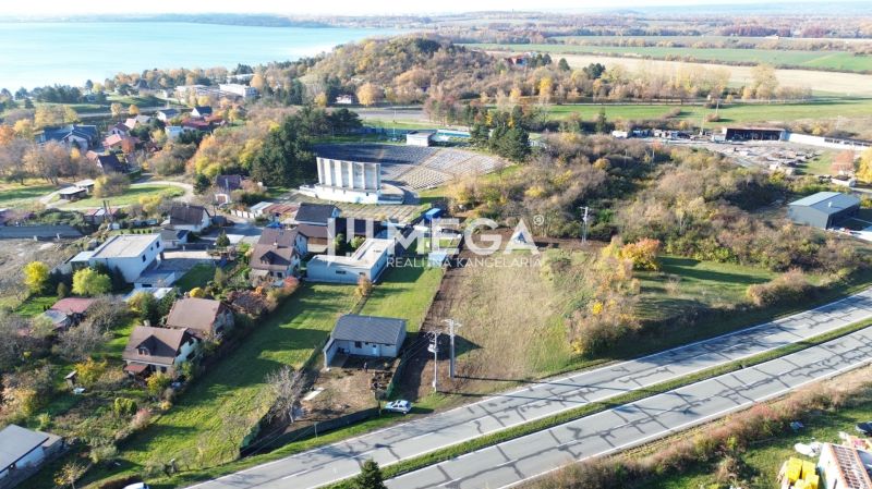 Panoramic view of residential plots in Vinné with a nearby lake.