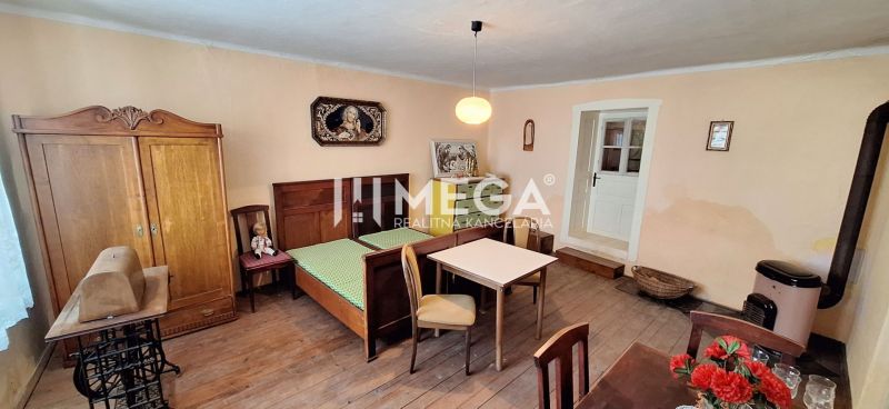 A room in a family house with a bed, furniture, and a wooden decor floor.