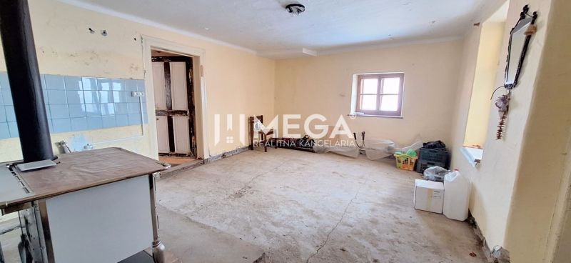 A room in a family house with a simple kitchen stove and a concrete floor.