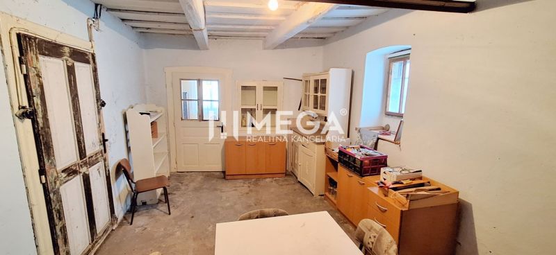 Interior of a family house with a wooden ceiling, old doors, and furniture.