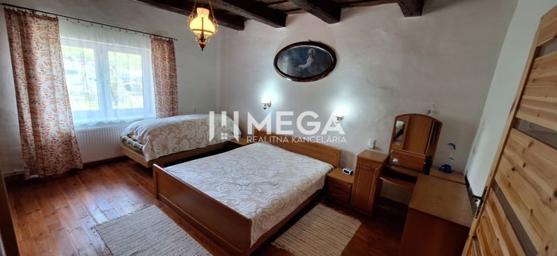 A bedroom in a family house with wooden beams and a floor with a wooden decor.